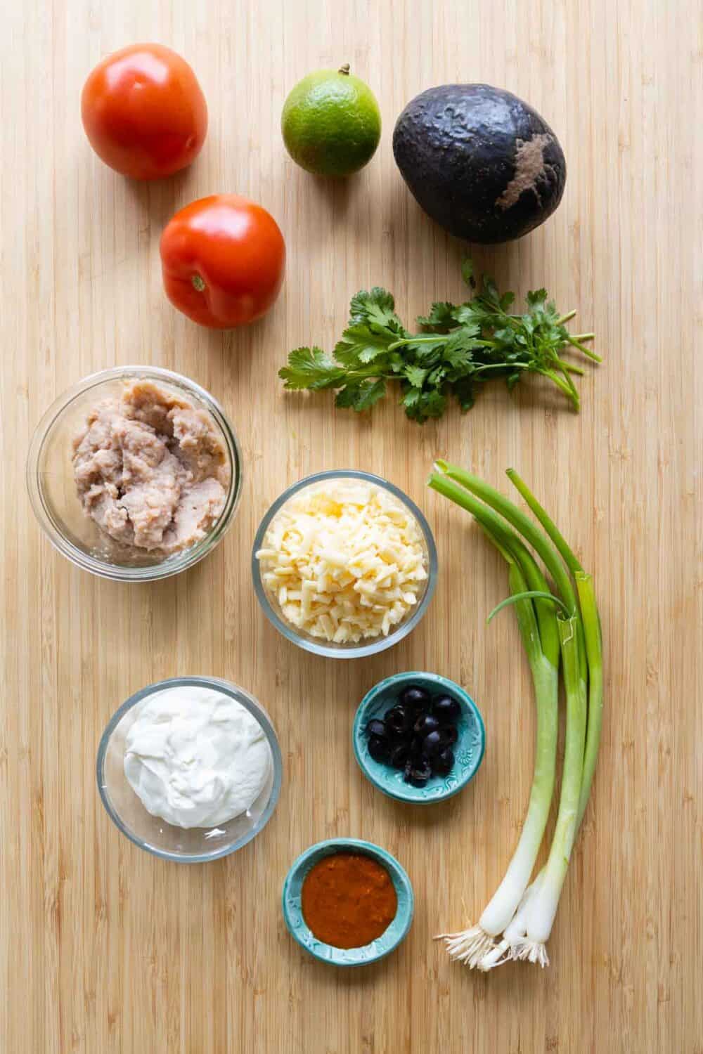 Ingredients for quick and easy 7-Layer Dip laid out on a kitchen counter.