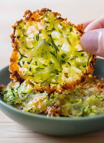 Zucchini cheese crisp being lifted off a plate.