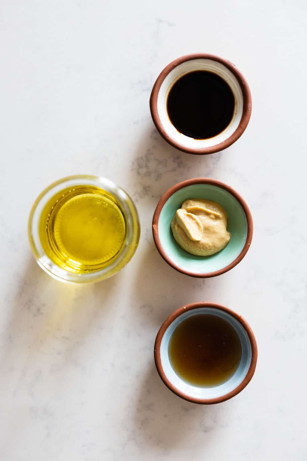 Ingredients for Maple Mustard Balsamic Dressing laid out on a kitchen counter.