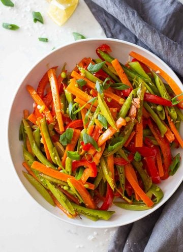A white plate loaded with sliced roasted vegetables.
