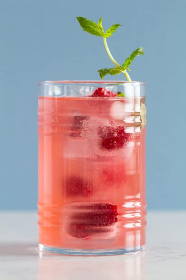 Pink Lemonade, ice cubes, raspberries, and mint in a glass 