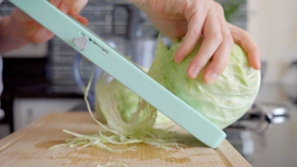 slicing cabbage with a green mandoline