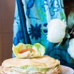 My Mum's Crepe Cake on a plate on a blue table with a blue floral scarf in the background.