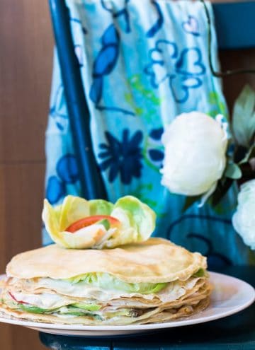My Mum's Crepe Cake on a plate on a blue table with a blue floral scarf in the background.
