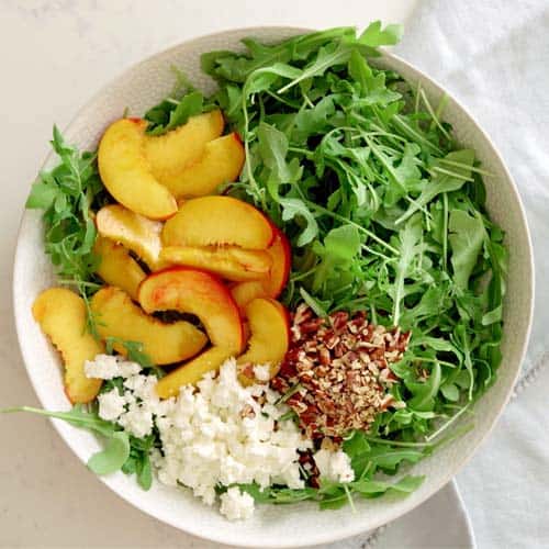 assembled nectarine arugula salad with feta and pecans