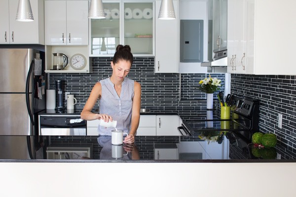 Green Healthy Cooking author in her new shiny kitchen pouring milk in a cup.