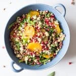 Finished whole bowl of winter salad with romaine lettuce, orange slices, chopped pecans, blue cheese and pomegranate seeds.