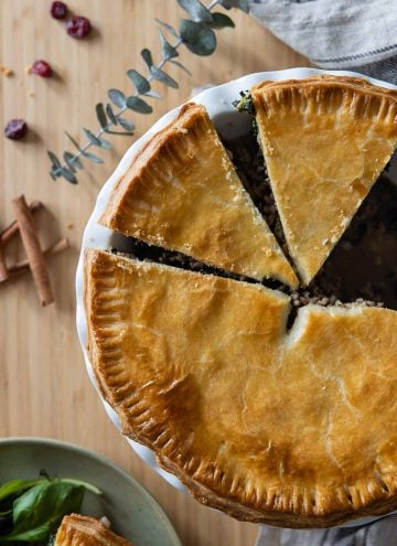 Tourtière meat pie cut up into pieces in baking dish.