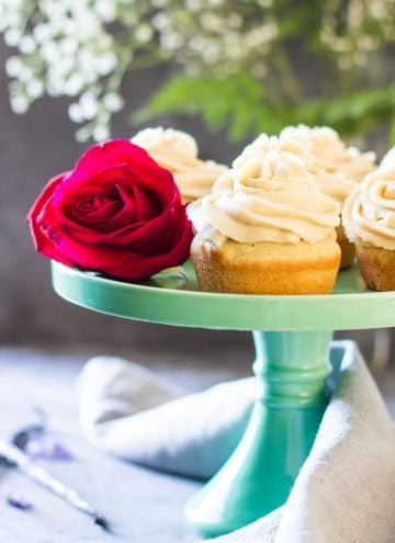 Moist Vanilla Cupcakes on a green cake stand with a rose.