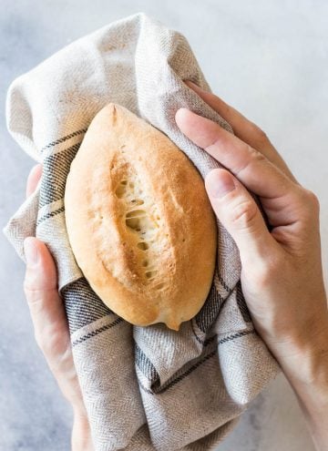 Bolillo on top of kitchen towel held in hand