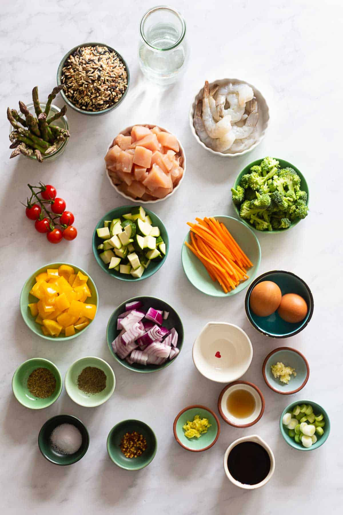 All ingredients needed to meal prep 4 different lunches in separate bowls.