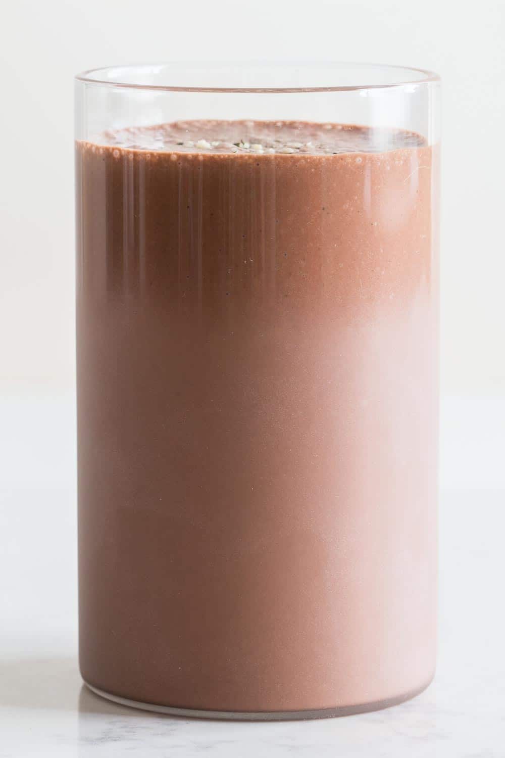 A glass full of vegan Chocolate Peanut Butter Banana Smoothie.