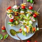 Antipasto Skewers drizzeled with green pesto on a plate