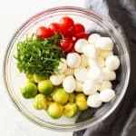 Ingredients for Avocado Tomato Salad in a glass bowl