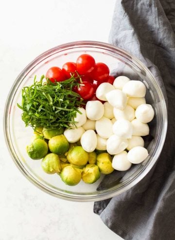 Ingredients for Avocado Tomato Salad in a glass bowl
