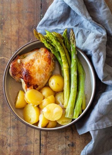 Instant Pot Lemon Chicken on a plate with potatoes and asparagus