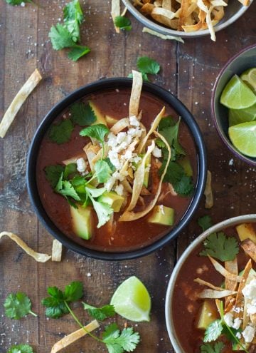 Crock Pot Chicken Tortilla Soup topped with crispy tortilla strips, avocado, cilantro and queso fresco