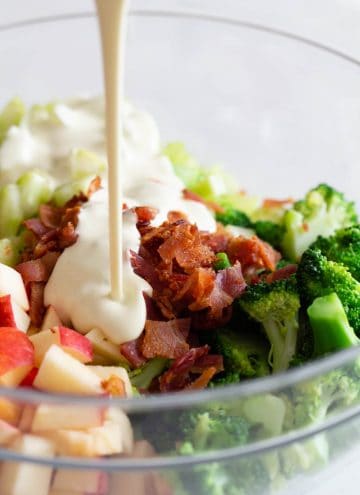 Broccoli Salad in a bowl and dressing poured in