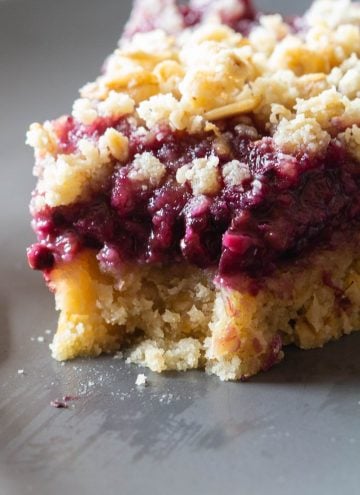 One piece of a Blackberry Pie with crumbles on top.