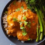texture of butter chicken in a grey bowl over white rice