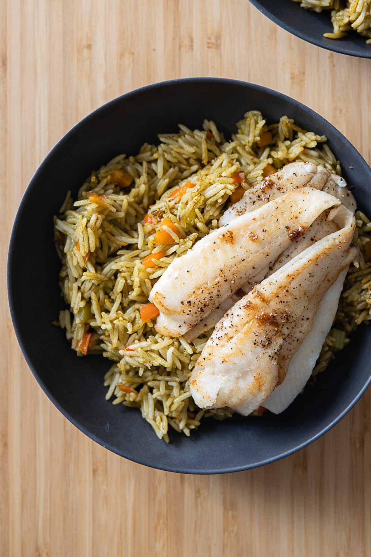 Green Rice and sole fillet in a grey bowl.