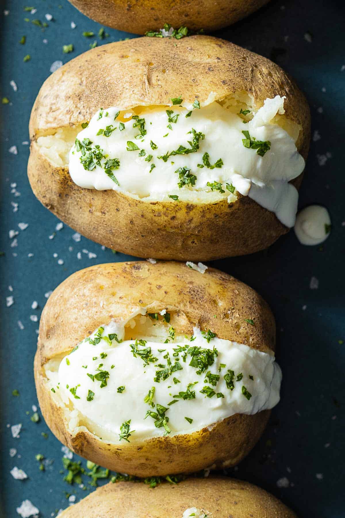 Baked Potatoes topped with sour cream and chopped parsley.