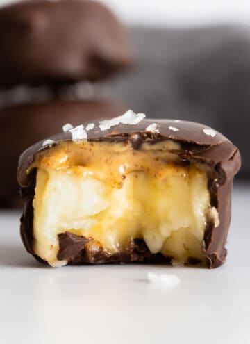 One chocolate covered banana bite bitten into to show inside texture.