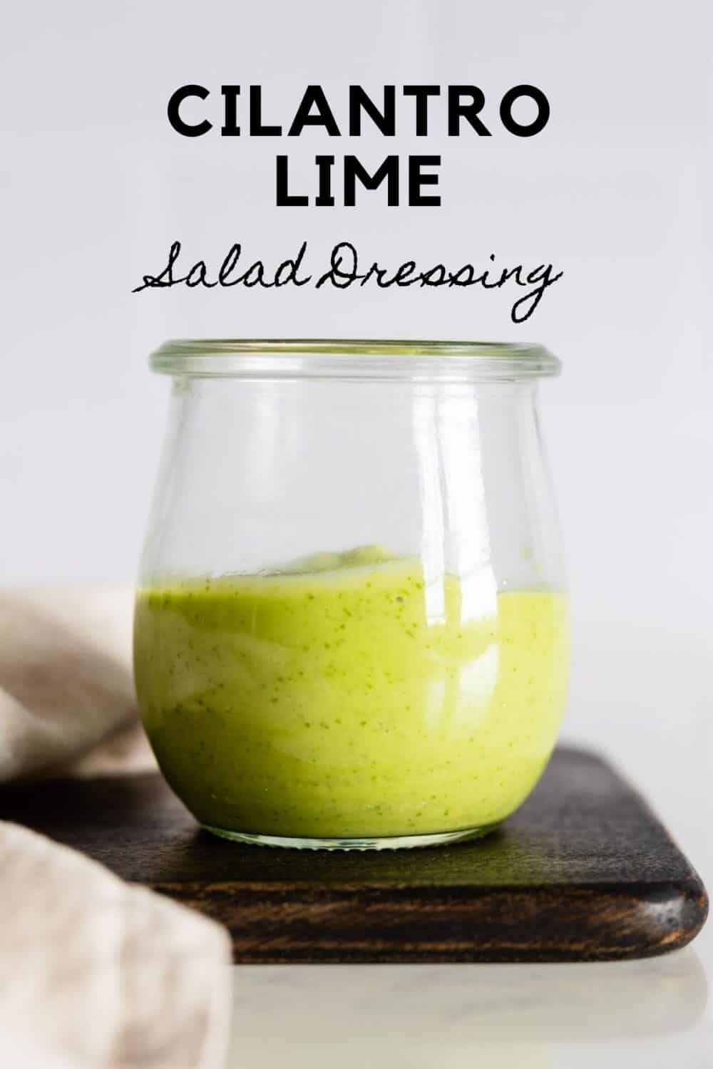 Glass jar with green salad dressing with title reading: Cilantro Lime Salad Dressing.