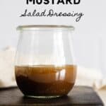 Glass jar with brown salad dressing with title reading: Maple Mustard Salad Dressing.
