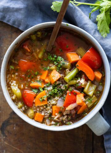sou with colorful vegetables and ground beef in a small grey bowl.