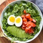 Breakfast salad made of arugula, tomato, avocado, and hard-boiled egg.