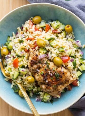 Mediterranean Chicken Orzo in a blue bowl with a golden fork.