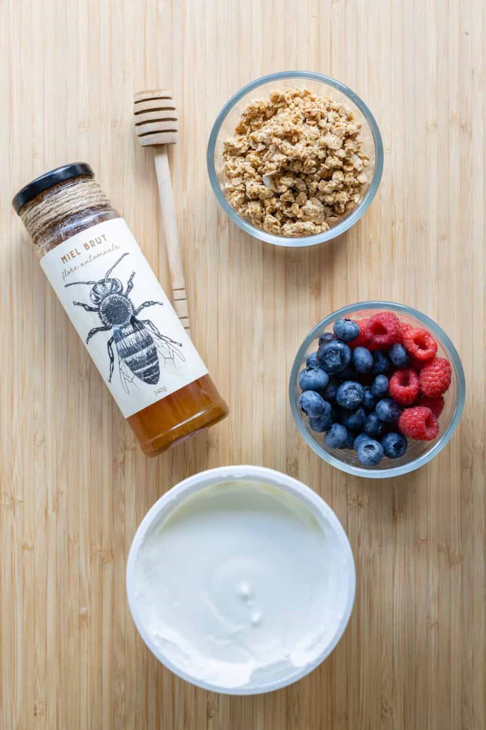Ingredients for Greek Yogurt Parfait laid out on a kitchen counter.